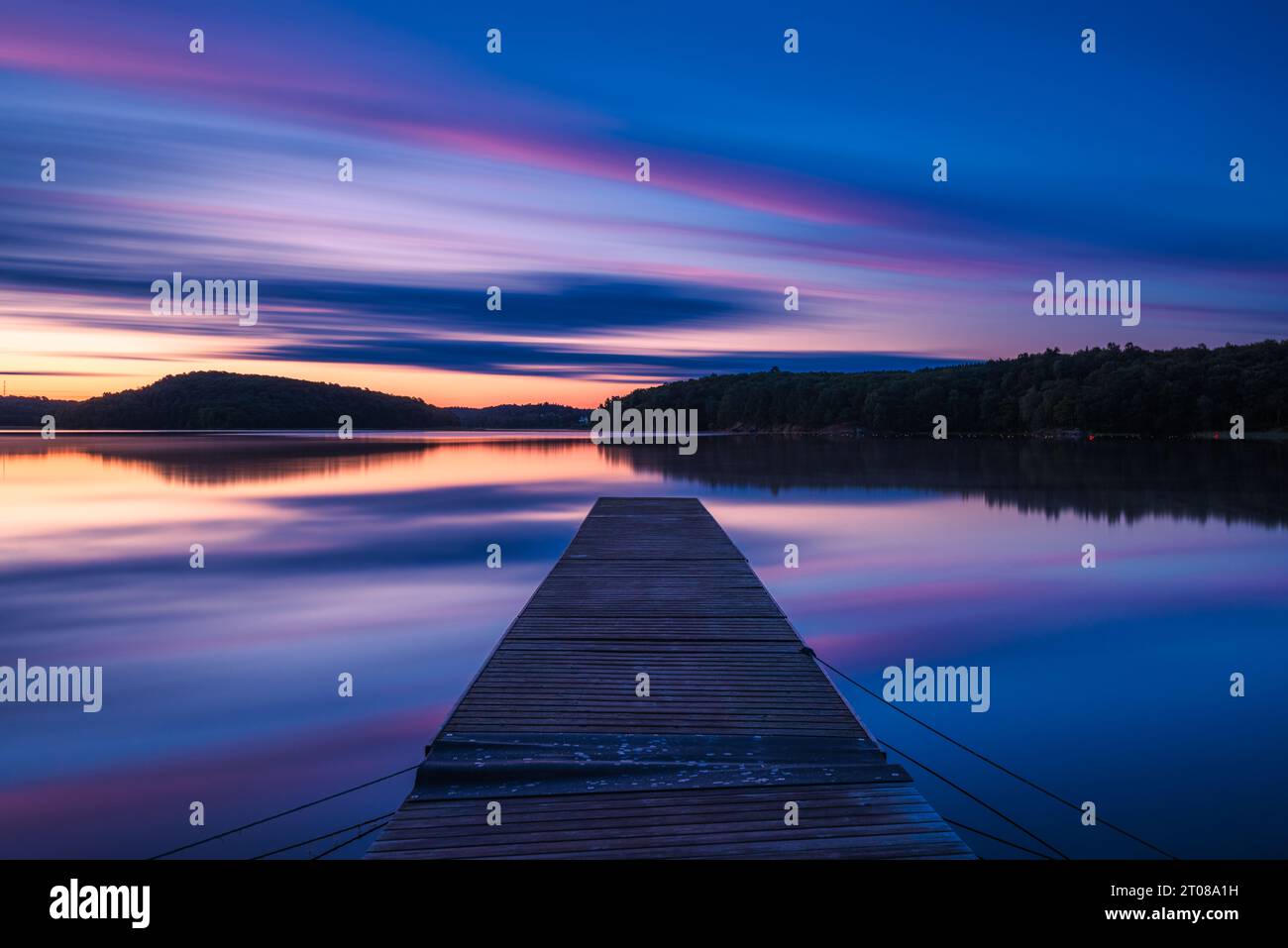 Ruhige Szene bei Sonnenaufgang: Ruhiger See, friedlicher Pier, atemberaubender Sonnenaufgang. Stockfoto