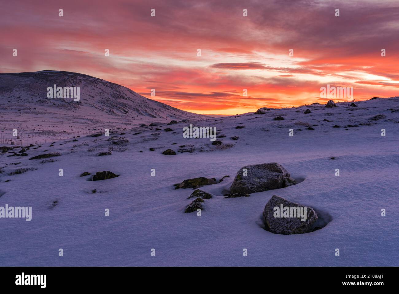 Eine beschauliche Winterberglandschaft mit dramatischem Himmel bei Sonnenaufgang Stockfoto