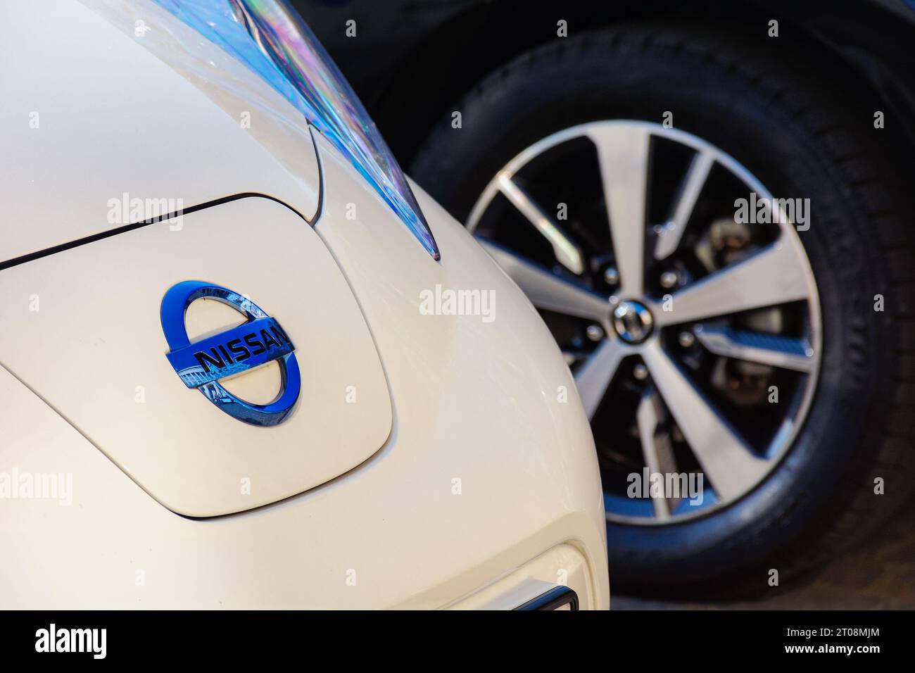 nissan-Ornament auf der Motorhaube eines Elektroautos mit weißem Blatt. Nahaufnahme im Freien Stockfoto