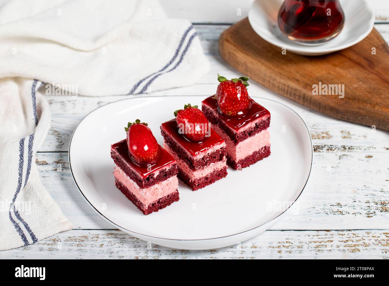 Kleine Scheiben Kuchen. Erdbeeren- und Sahnetuchscheiben auf einem Teller. Snack süße Speisen. Nahaufnahme Stockfoto