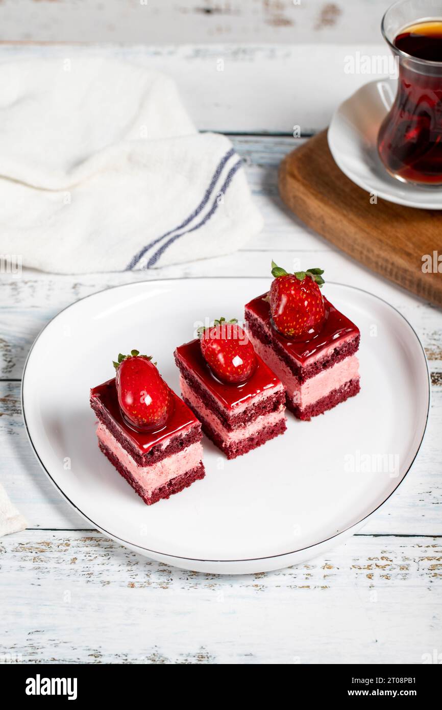 Kleine Scheiben Kuchen. Erdbeeren- und Sahnetuchscheiben auf einem Teller. Snack süße Speisen Stockfoto