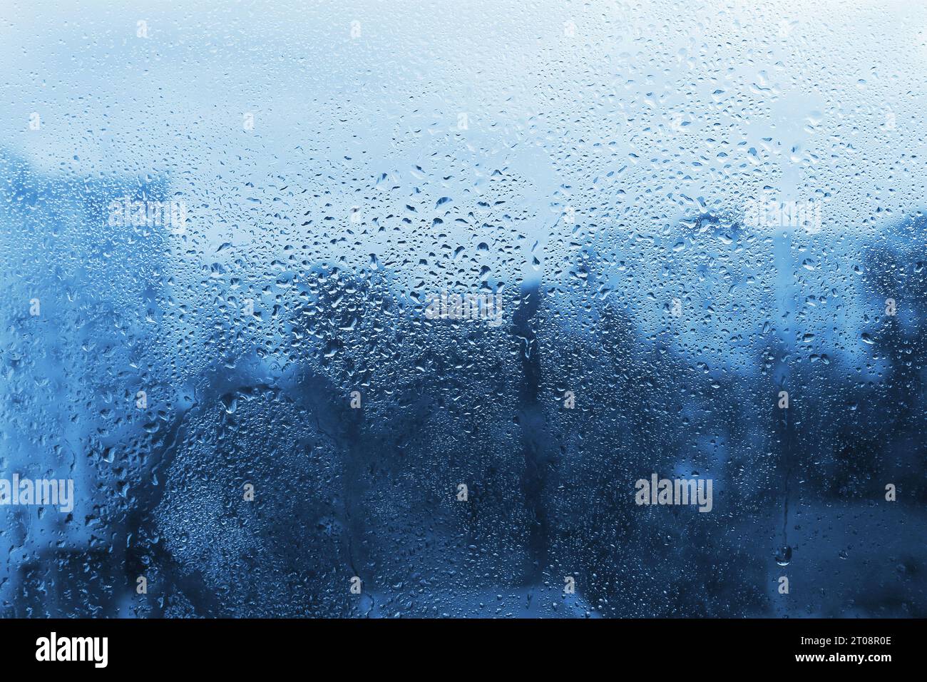 Wassertropfen auf Fensterglas, blauer natürlicher Hintergrund Stockfoto