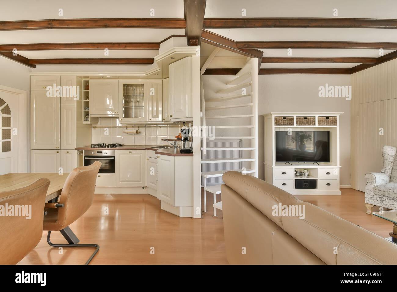 Innenraum des Wohnzimmers mit Couch und Fernseher in einem modernen Haus mit offener Küche Stockfoto