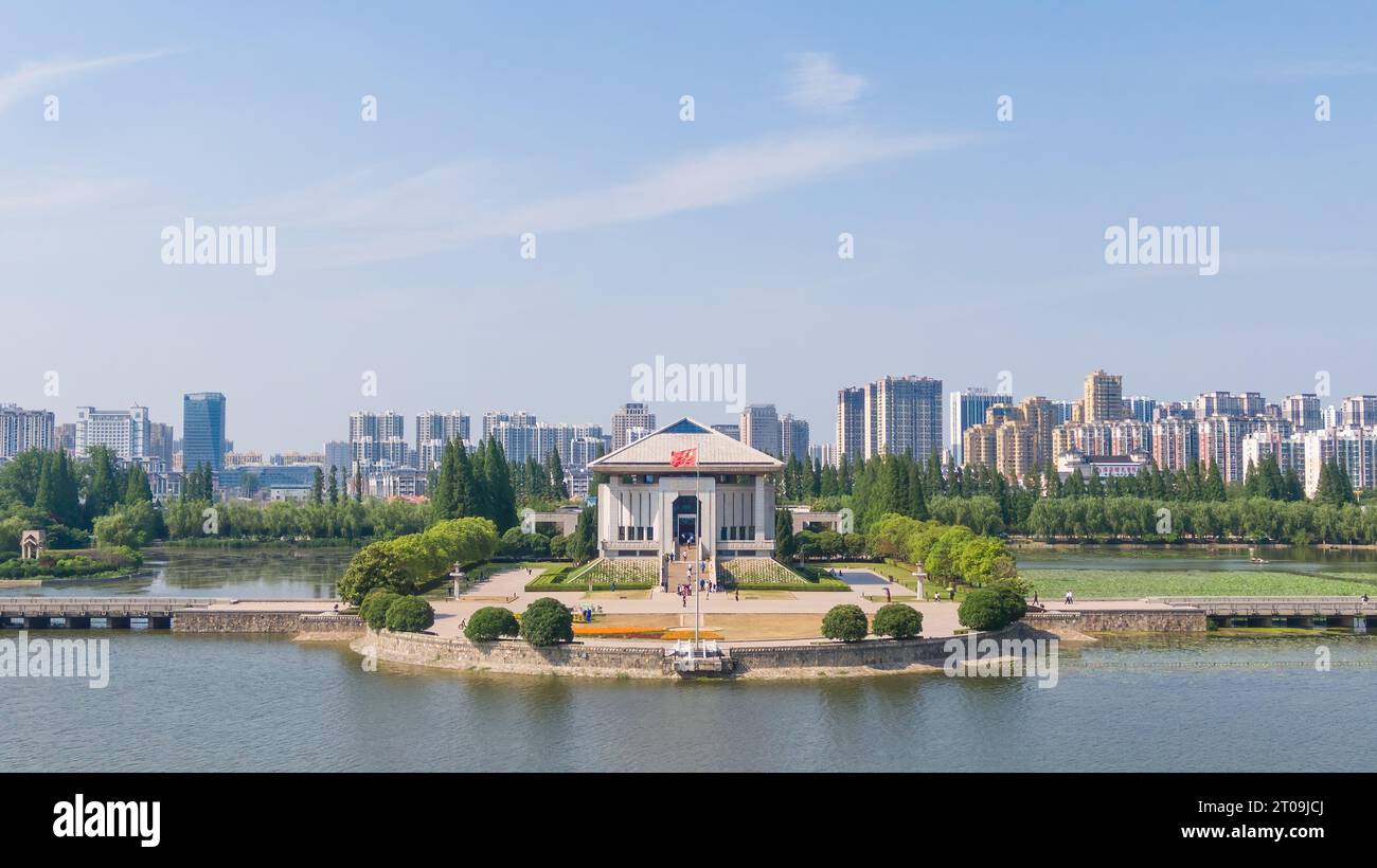 Aus großer Höhe aus der Vogelperspektive auf den gewundenen Fluss und die Zhou Enlai Memorial Hall in Huai'an City, China Stockfoto