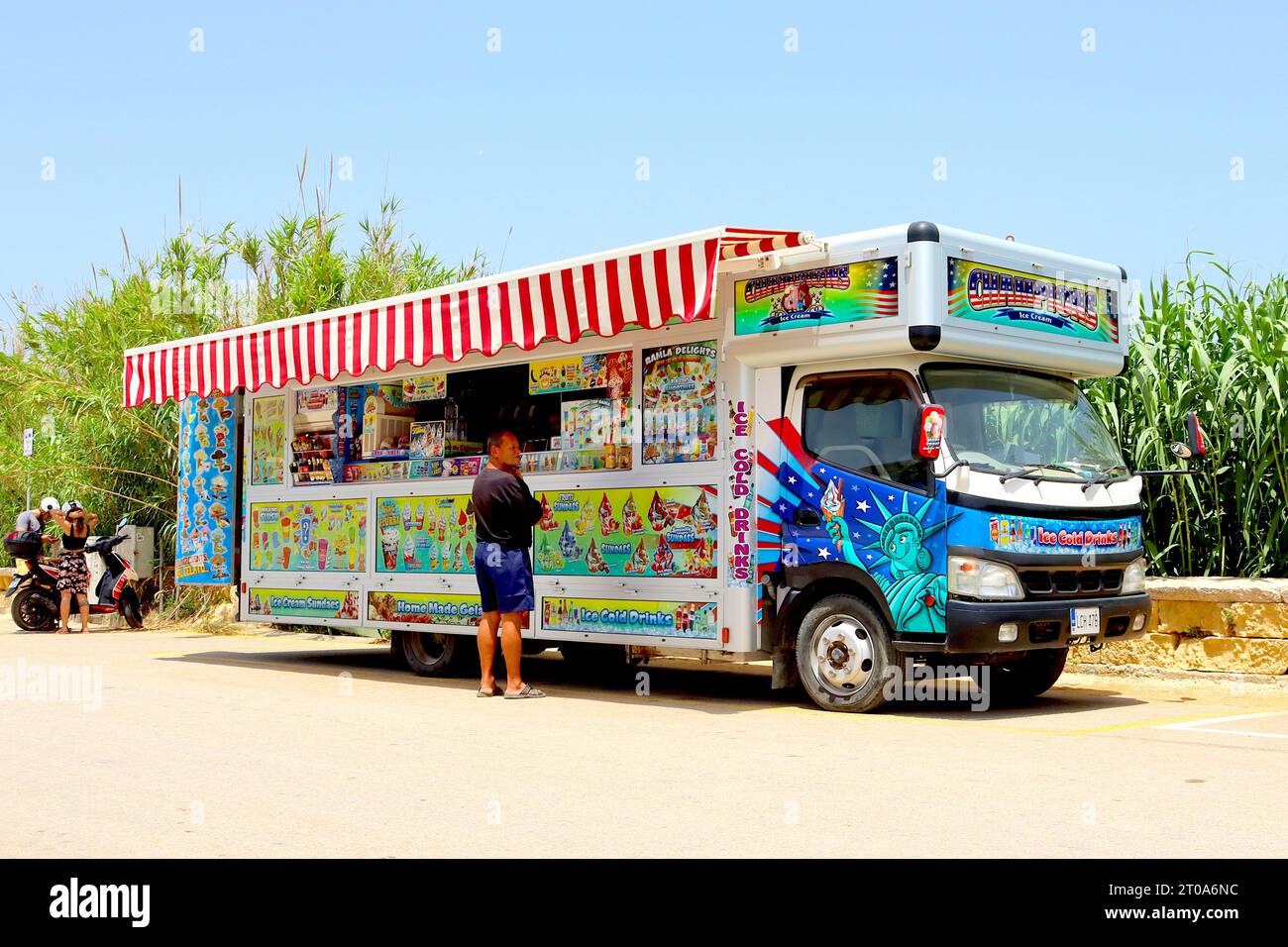 Ein Kunde denkt über die große Auswahl eiskalter Erfrischungen nach, die im Juni 2022 im Champions Ice Cream Truck in Ramla Bay, Gozo, Malta, angeboten werden. Stockfoto