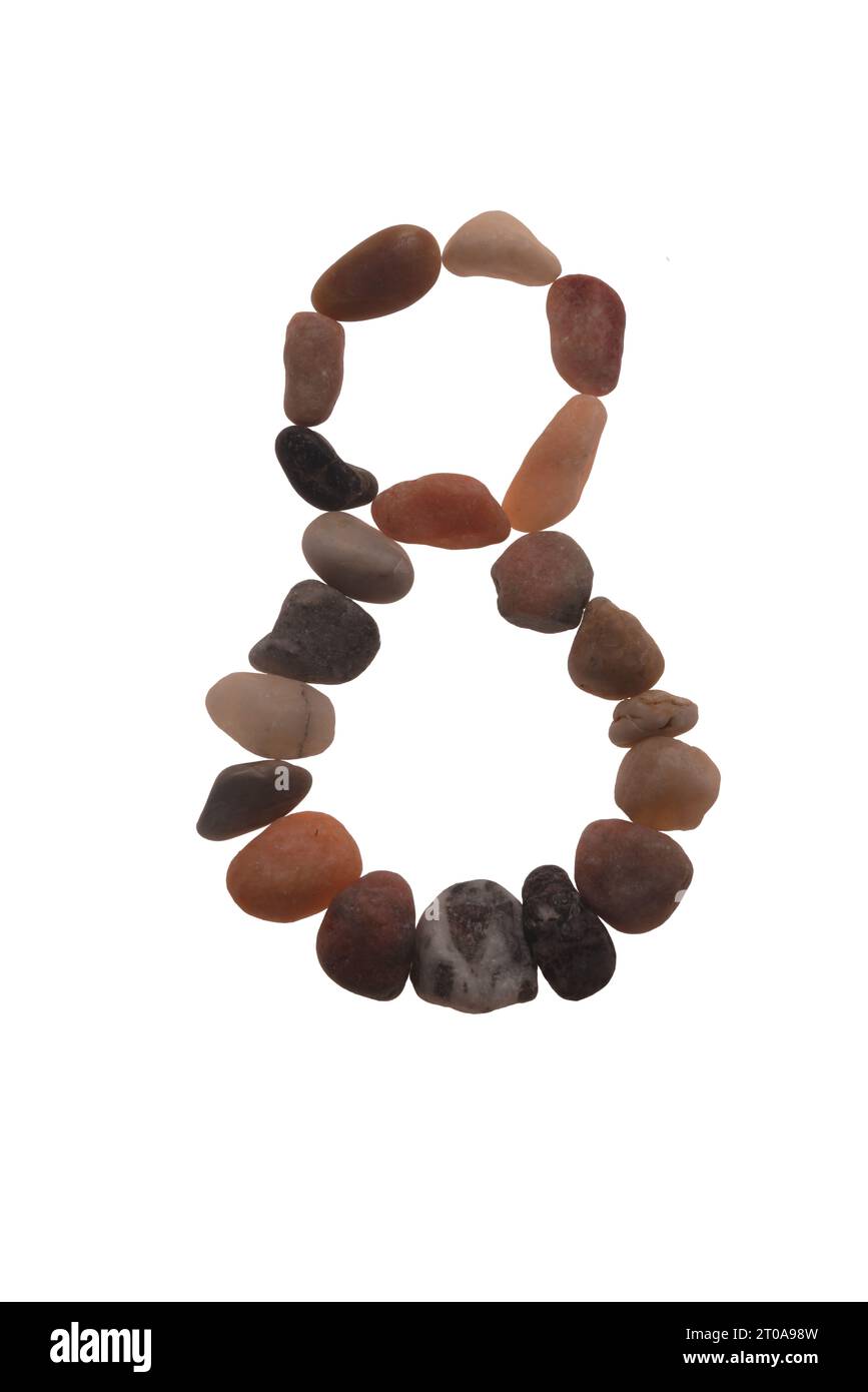 8 handgefertigte Schriftart aus Steinen, Zeichen der Natur, Stärke, Stabilität und Langlebigkeit. Auffällige zufällige Muster, Linien, Formen, weißer Hintergrund Stockfoto