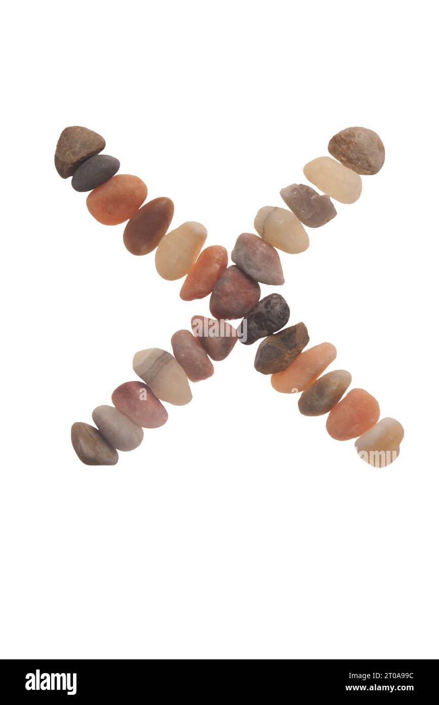 X handgefertigte Schriftart aus Steinen, Zeichen der Natur, Stärke, Stabilität und Langlebigkeit. Auffällige zufällige Muster, Linien, Formen, weißer Hintergrund Stockfoto
