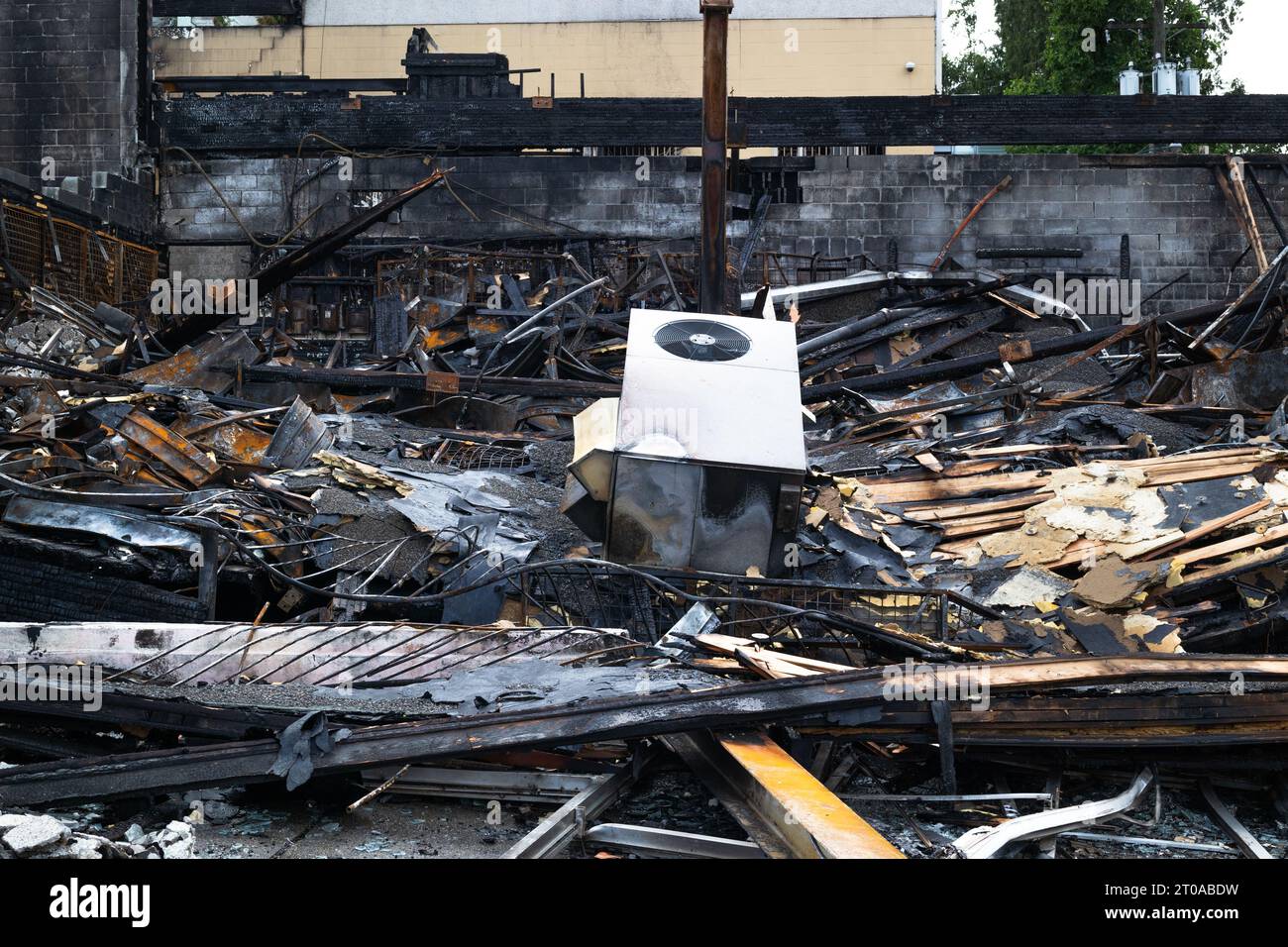 Das Gebäude brannte bis auf den Boden. Vollständige Zerstörung des Gebäudes nach Ausbruch eines Brandes im Untergeschoss Verkohltes, zusammengeklapptes Gebäude mit Holzbalken, gebogen Stockfoto