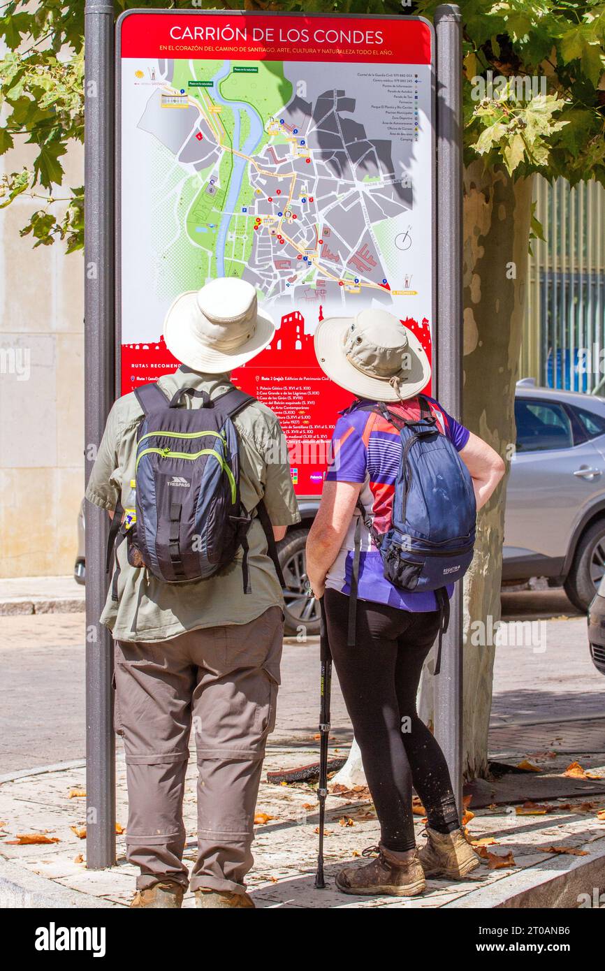 Mann und Frau, die sich eine Karte der spanischen Stadt Carrion de los Condes anschauen, während Sie auf dem Jakobsweg auf dem Jakobsweg spazieren Stockfoto