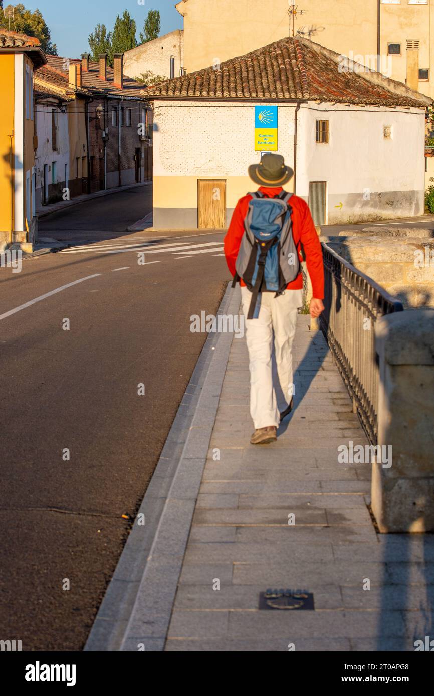 Pilger, die über die Brücke in der spanischen Stadt Carrion spazieren, während Sie den Jakobsweg in Spanien entlang gehen Stockfoto