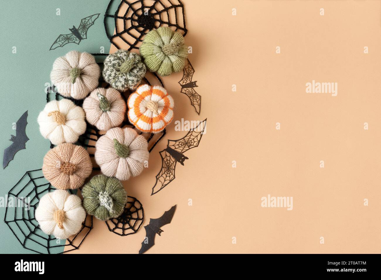 Halloween Grußkarte Mockup mit Kopierraum. Halloween-Dekorationen, Spinnen, Fledermäuse, gestrickte Netze, Kürbisse auf grünem und beigem Hintergrund. Happy Hall Stockfoto