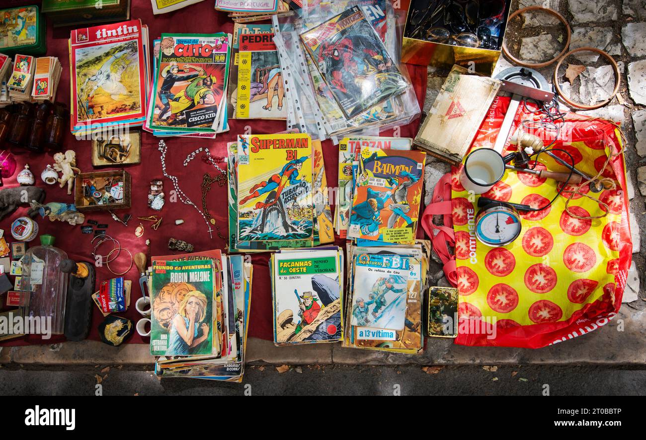Feira da Ladra (Diebe-Markt) Lissabon, Portugal. Alte Comic-Bücher und BRIC-a-Brac zum Verkauf und am Dienstagmorgen auf dem Gehweg auf dem Open-Air-Diebe-Markt am Campo de Santa Clara im Alfama-Viertel der Hauptstadt. Der zweitägige Wochenmarkt (Dienstag und Samstag) stammt aus dem 13. Jahrhundert und befindet sich seit 1903 in Lissabon Stockfoto