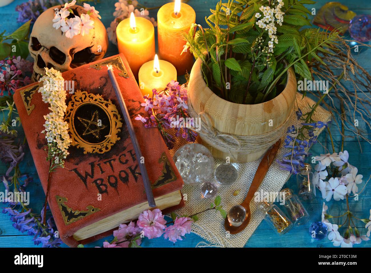 Altes Hexenbuch mit Mörser und Kerzen auf Ritualaltar-Tisch. Okkultes, esoterisches und glücksreiches Stillleben. Mystischer Hintergrund mit Vintage-Objekten Stockfoto