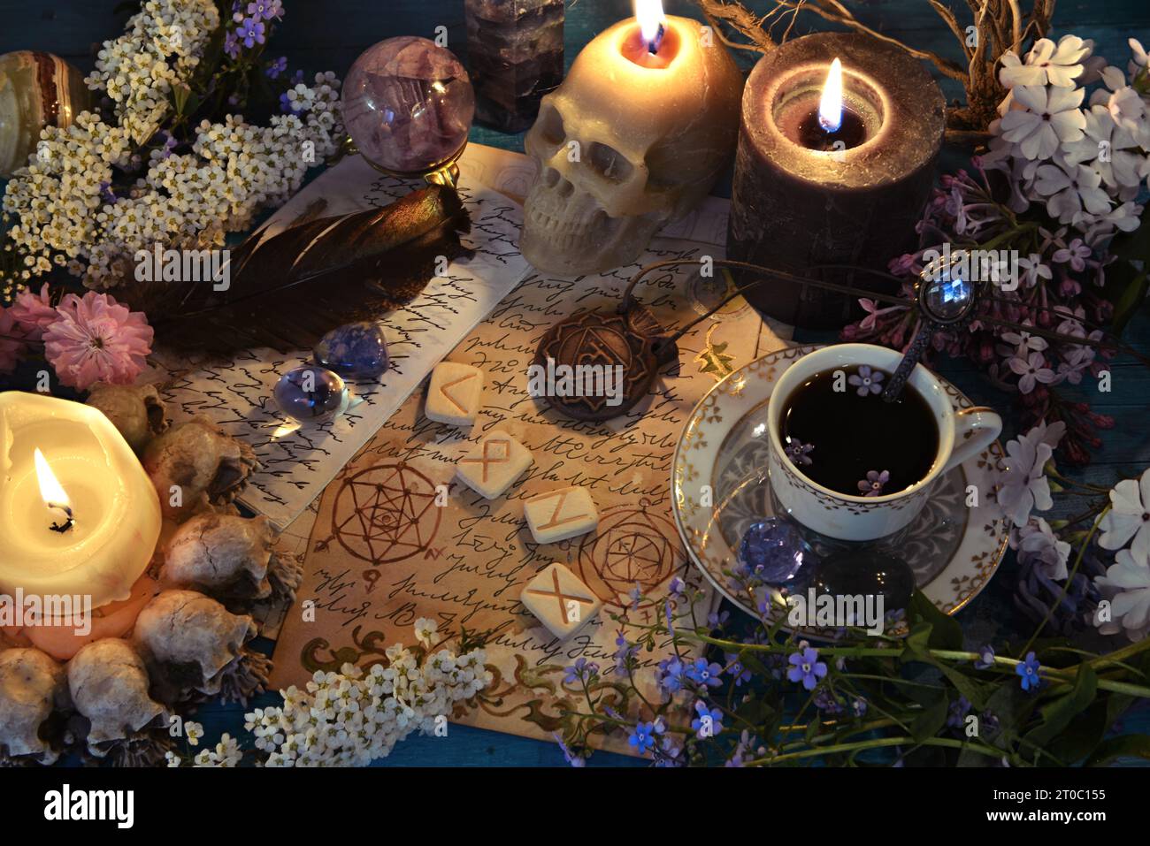 Schädelkerzen, Manuskripte mit Zauberzaubern und Runen auf dem Hexenaltar. Okkultes, esoterisches und glücksreiches Stillleben. Mystischer Hintergrund mit V Stockfoto