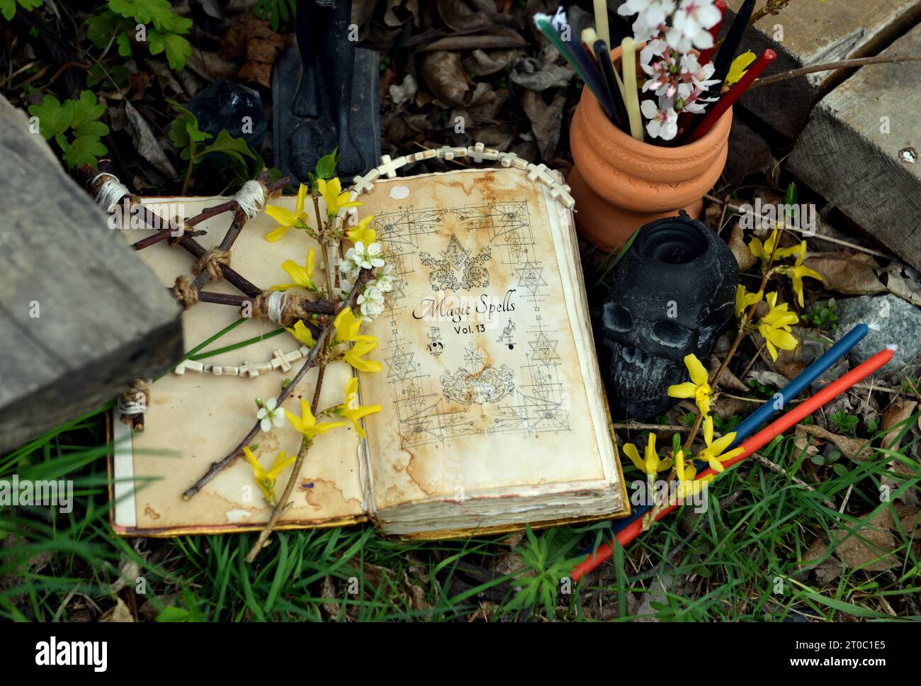 Zauberbuch mit Zaubersprüchen, Kerzen und Pentagramm auf Ritualaltar im Gras. Okkultes, esoterisches und Wahrsagungsstilleben. Mystischer Hintergrund mit Vinta Stockfoto
