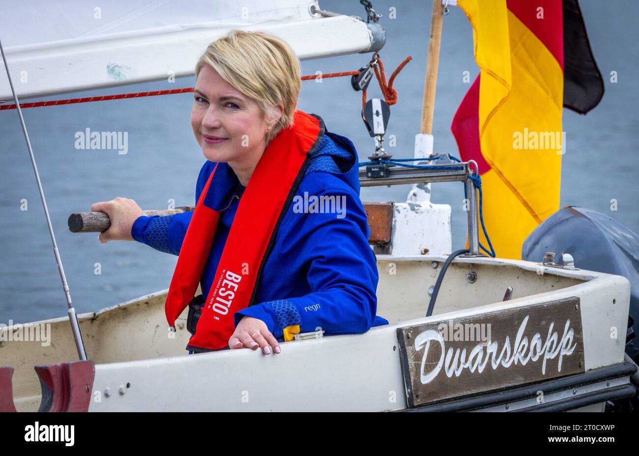 Schwerin, Deutschland. Oktober 2023. Manuela Schwesig (SPD), Ministerpräsidentin Mecklenburg-Vorpommerns, steuert das Segelboot „Dwarskoop“ mit dem Logo der mecklenburg-Vorpommerschen Bundesratspräsidentschaft, das am 1. November 2023 unter dem Motto „Set Sail united“ beginnt. Dies ist das dritte Mal, dass der Staat den Bundesrat präsidiert. Quelle: Jens Büttner/dpa/Alamy Live News Stockfoto