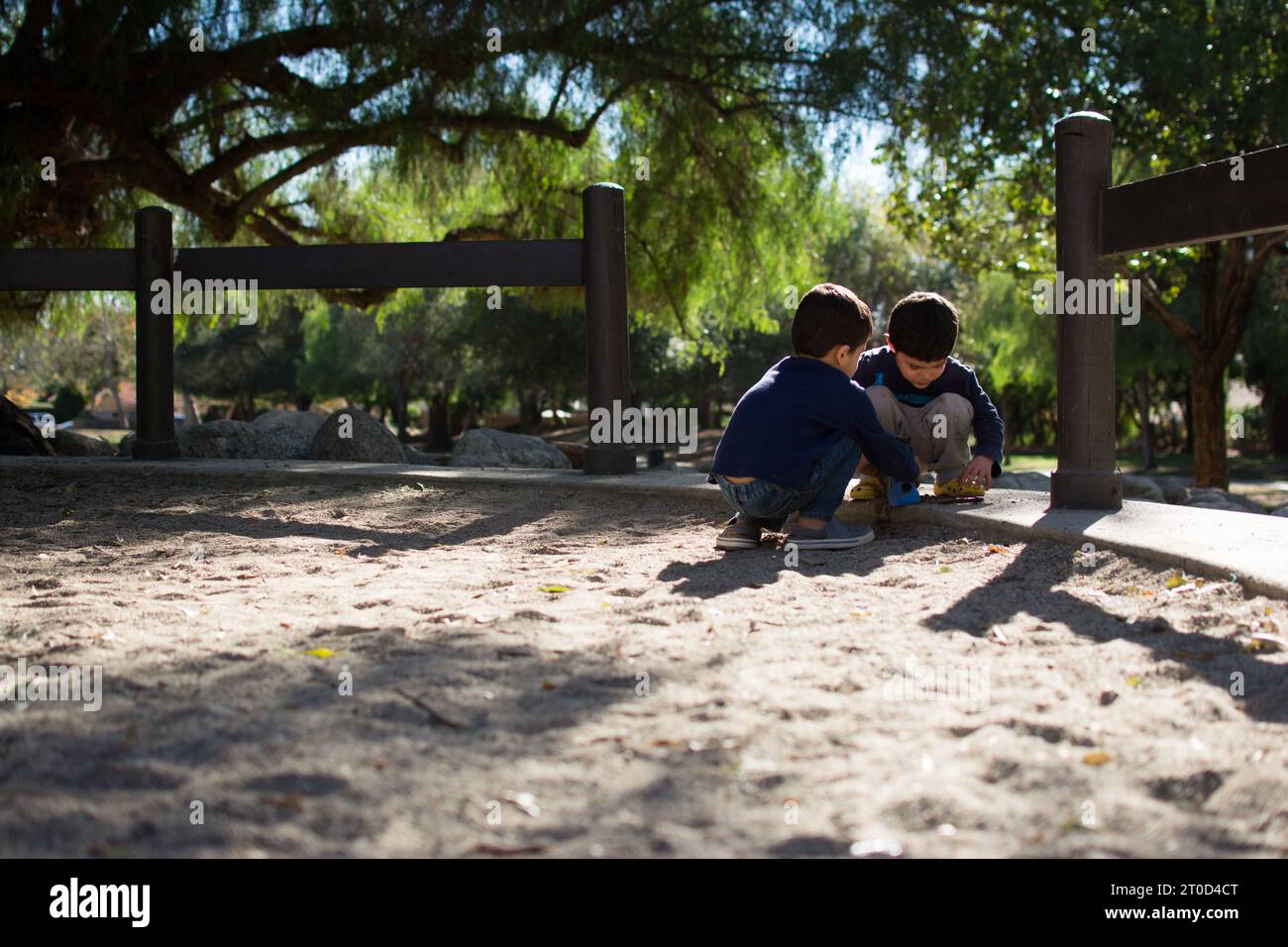 Junge Jungs spielen in Sandkasten auf einem Vorstadtspielplatz. Stockfoto