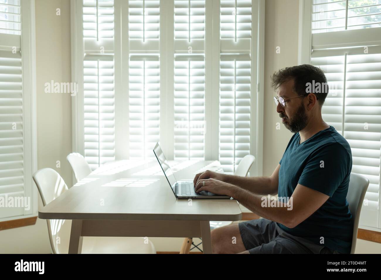 Ein bärtiger Mann in Brille arbeitet am Laptop Stockfoto