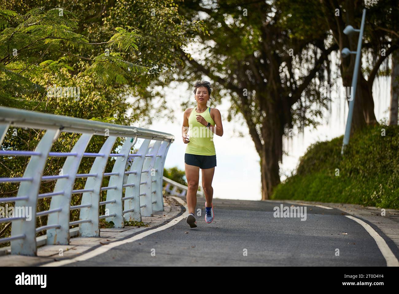 Junge asiatische Frau, die im Stadtpark Joggen läuft Stockfoto