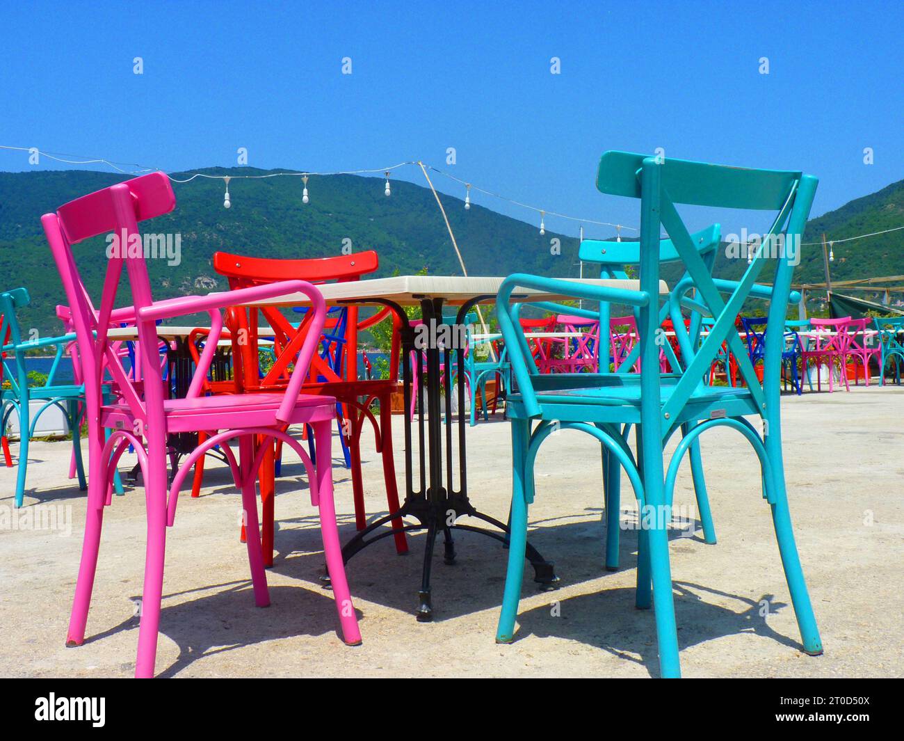 Farbenfrohe Holzstühle mit Blick auf das Meer Stockfoto