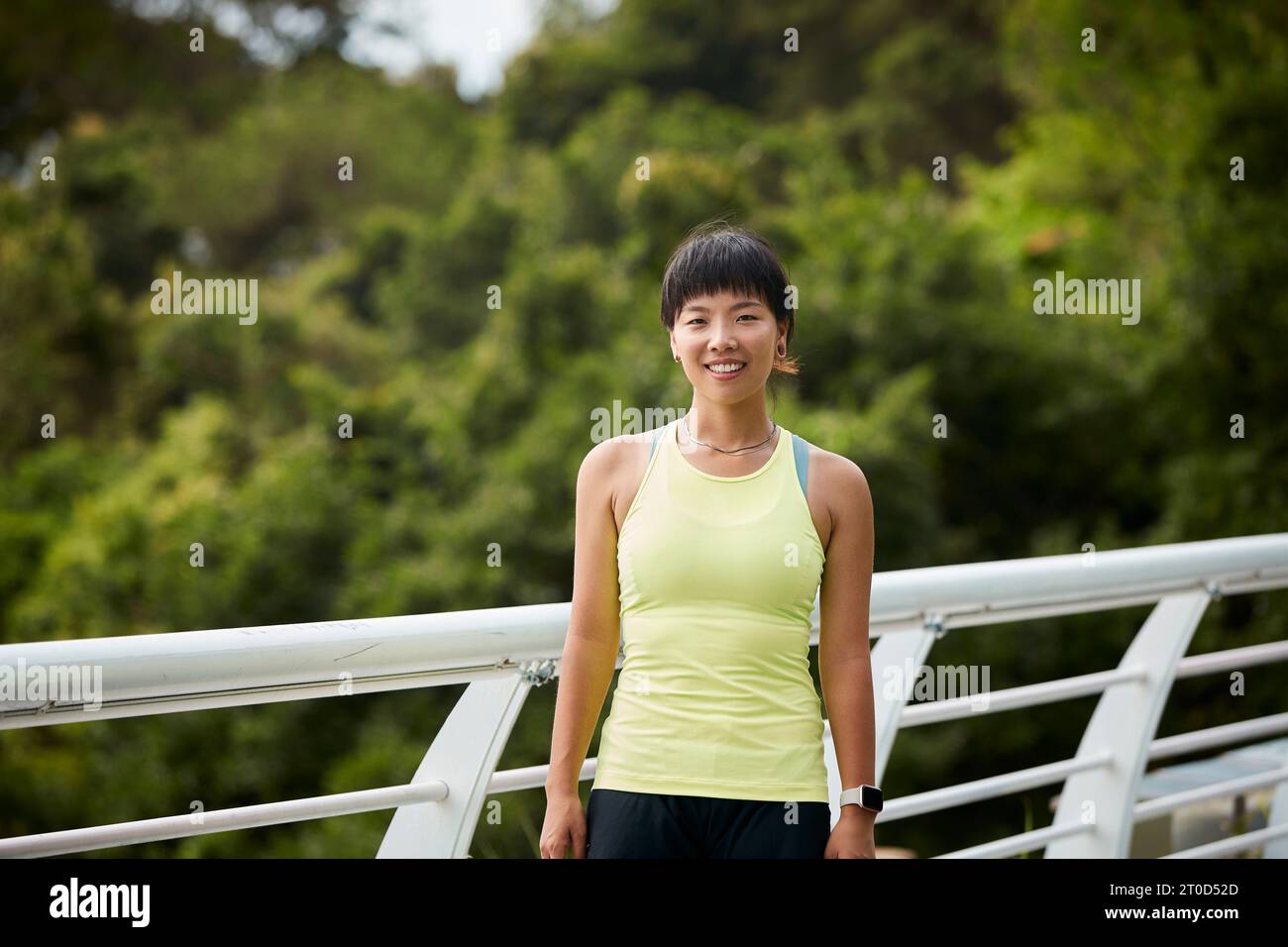 Außenporträt einer glücklichen jungen asiatischen Sportlerin Stockfoto