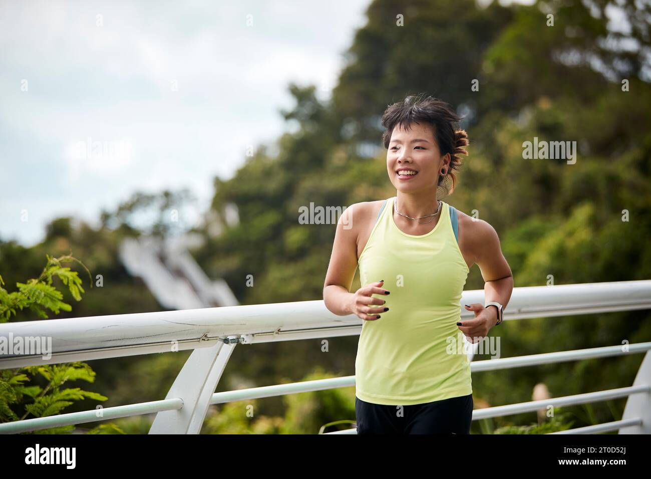 Junge asiatische Frau, die im Stadtpark Joggen läuft Stockfoto