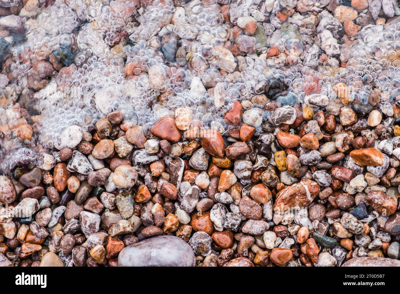 Sprudelndes Wasser fließt über Steine am Lake Superior in Michigan. Stockfoto