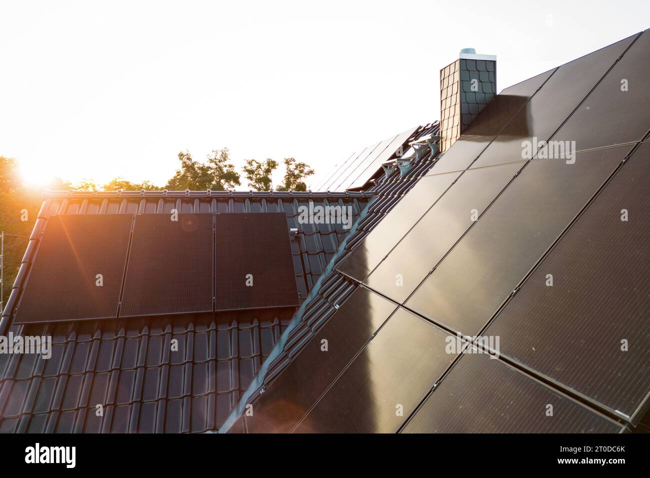 Solarpaneele auf dem Dach eines nachhaltigen Einfamilienhauses bei Sonnenuntergang Stockfoto