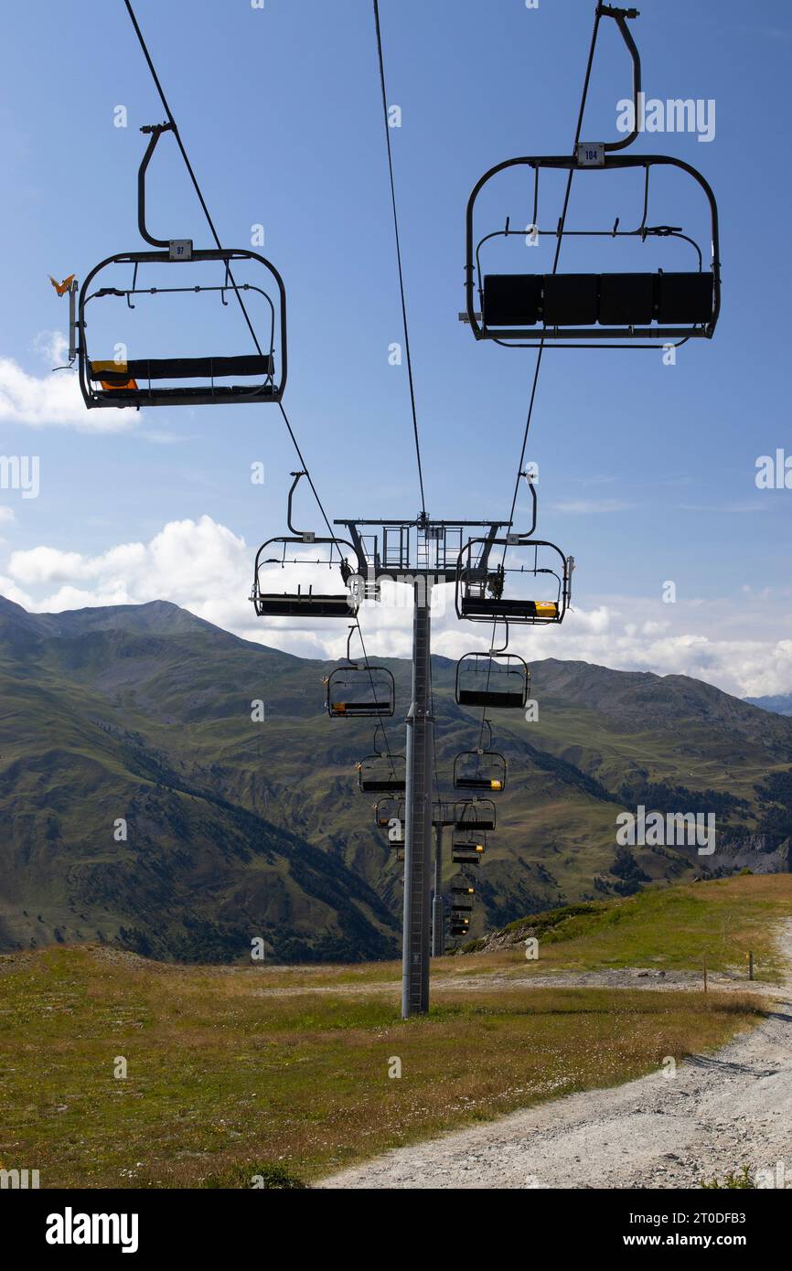 Ein leerer Skilift im Sommer, hoch oben in der Berglandschaft und im Hintergrund des blauen Himmels. Skigebiet Valloire in Frankreich. Kopieren Sie den Bereich darunter. Stockfoto