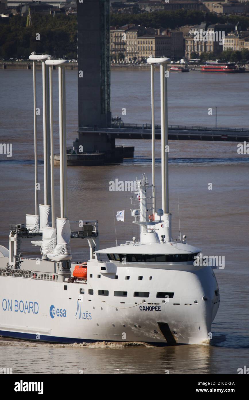 Das Bild vom 6. Oktober 2023 zeigt das 121 Meter lange Frachtschiff Canopee, die Canopée ist ein 121 Meter langes Frachtschiff, das von gigantischen Segeln angetrieben wird. Sie befindet sich derzeit in Bordeaux und soll Teile für die Ariane-6-Rakete nach Französisch-Guayana laden. Mit seinen vier 37 Meter hohen Masten hat das französische Schiff Canopée eine Segelfläche von 1.500 Quadratmetern. Dank der kombinierten Kraft seiner Motoren und des Windes wird dieses Hybrid-Frachtschiff Elemente der Ariane-6-Rakete nach Französisch-Guayana transportieren. Das 121-Meter-Schiff wird von 11 Besatzungsmitgliedern bemannt, die Kraftstoffeinsparungen zwischen 15 % und berichteten Stockfoto