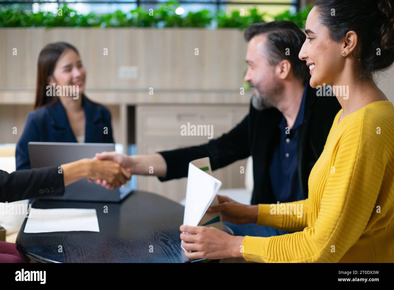 Geschäftsleute schütteln die Hände, nachdem sie ein Geschäftsvertragszeichen versiegelt haben. Gelegentliche Geschäftsverhandlungen im Büro. Teamarbeit und erfolgreiche Geschäfte Stockfoto