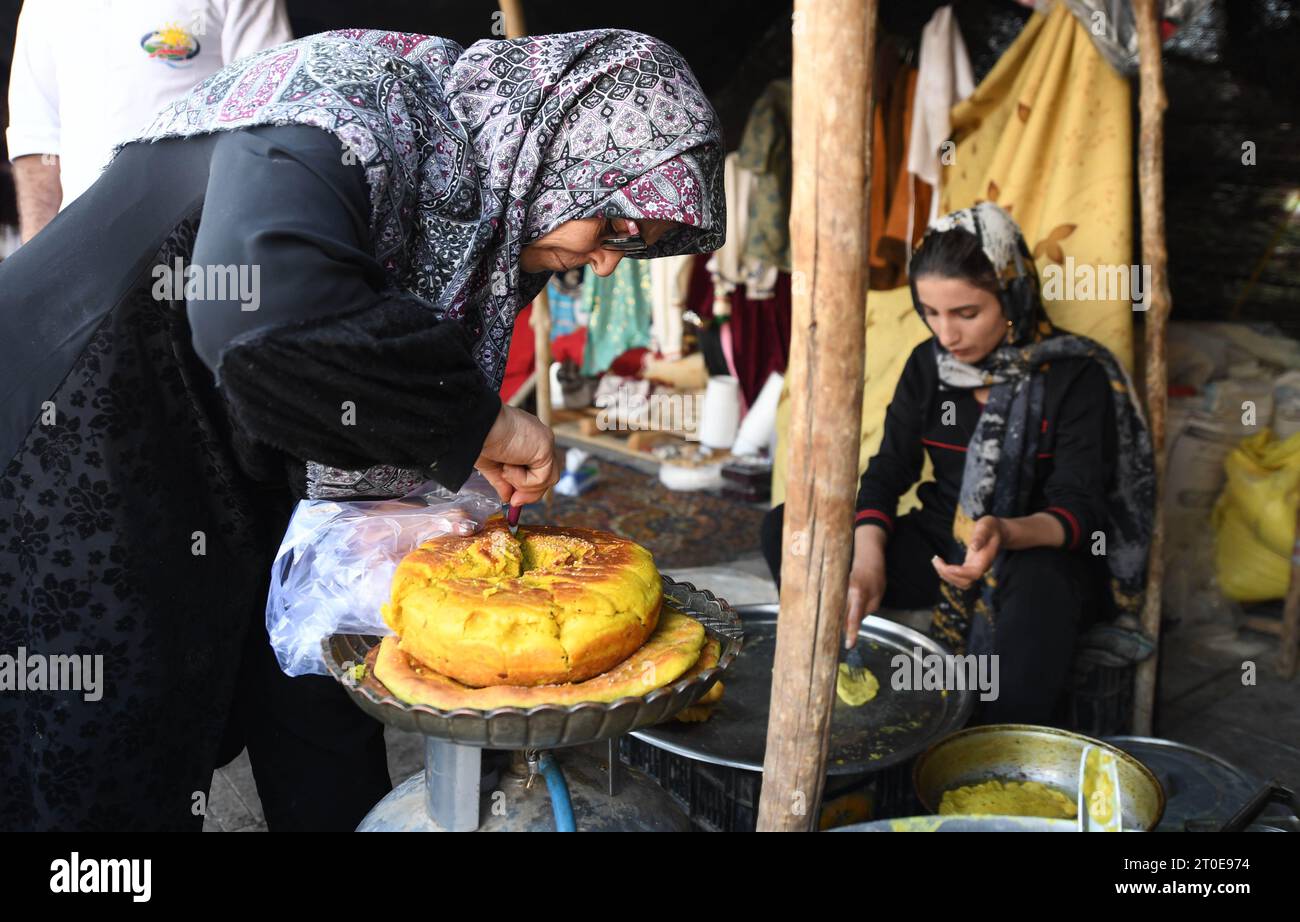 Teheran, Iran. Oktober 2023. Menschen machen traditionelle Lebensmittel in Teheran, Iran, 5. Oktober 2023. Menschen aus allen Teilen des Landes versammelten sich hier, um traditionelle Produkte auszustellen und zu verkaufen. Quelle: Shadati/Xinhua/Alamy Live News Stockfoto