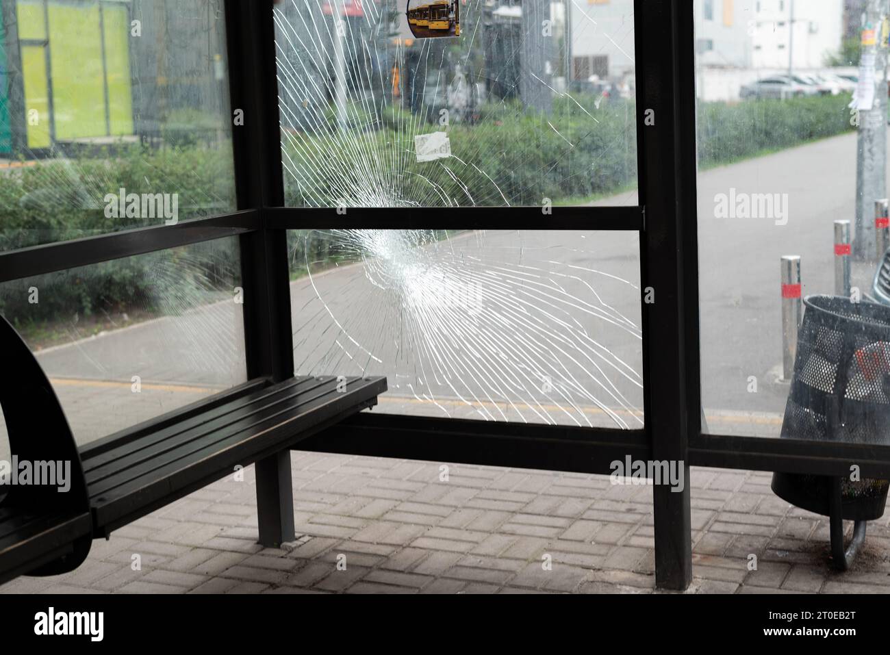 Glasbruch an der Bushaltestelle. Öffentlicher Nahverkehr, der durch die Glasfenster beschädigt wurde. Risse aus gehärtetem Glas Stockfoto