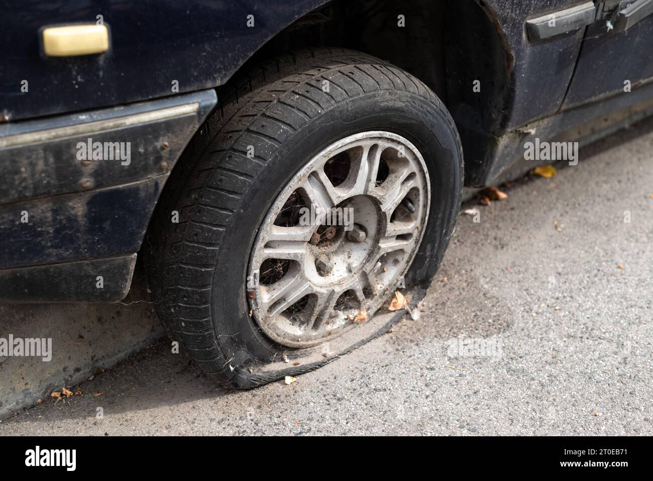 Close-up beschädigten Reifens. Das Rad der PKW-Reifen lecken. Reifenpanne warten auf die Reparatur. Verlassenes Auto auf dem Parkplatz. Stockfoto