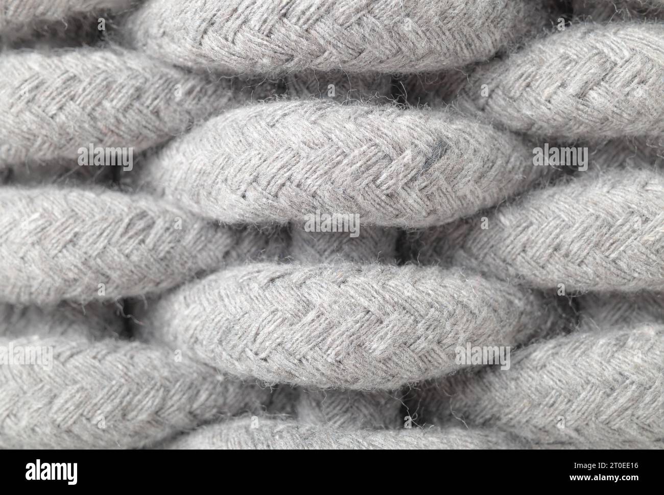 Gewebtes Korbmuster, Nahaufnahme. Makro aus hellgrauem, großem Webmuster aus gewebtem Baumwollseil. Textil-Hintergrundstruktur oder -Oberfläche. Selektiv Stockfoto