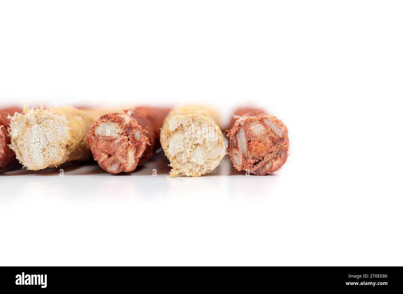 Rohleder Kaustangen für Hunde, Nahaufnahme. Vorne mit mehreren mit Hühnchen und Rindfleisch aromatisierten Kaustangen. Zahnärztliche Leckereien für Hunde und Verhalten en Stockfoto