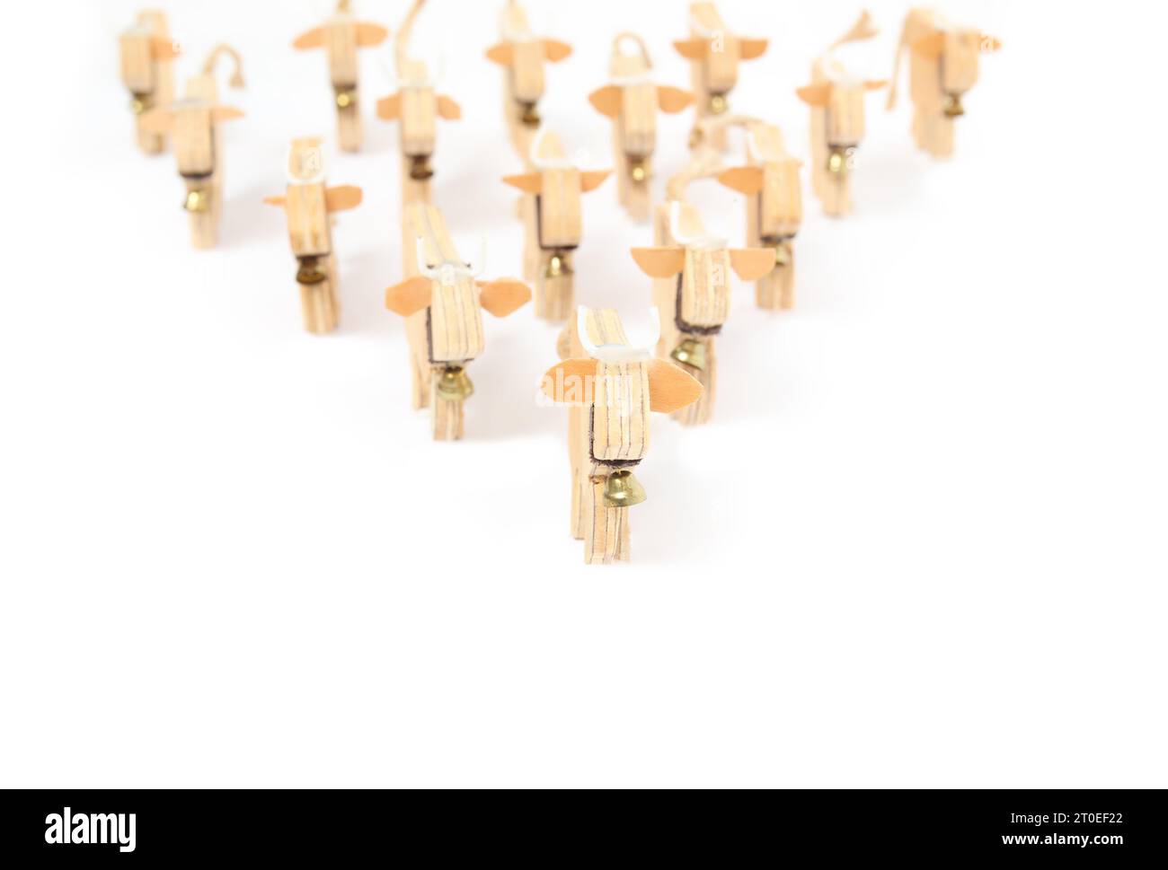 Holzkühe gehen zur Kamera. Konzept für Sieg, Führung, Zusammenstehen. Handgefertigte Kuhsilhouetten aus Holz mit Glocken in Pfeilform. Stockfoto