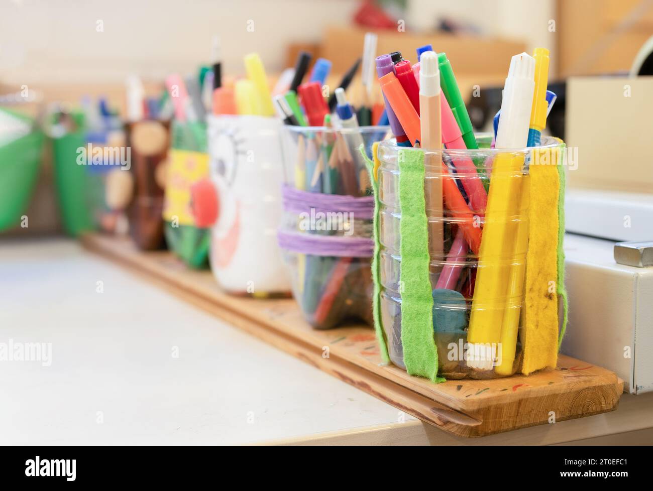 Viele Malstifte und Bleistifte in Bleistifthaltern auf dem Arbeitstisch in der Kunstklasse, im Atelier oder in der Schule. Kunst und Handwerk Hintergrundstruktur. Heimwerkerprojekt oder Kinder Stockfoto