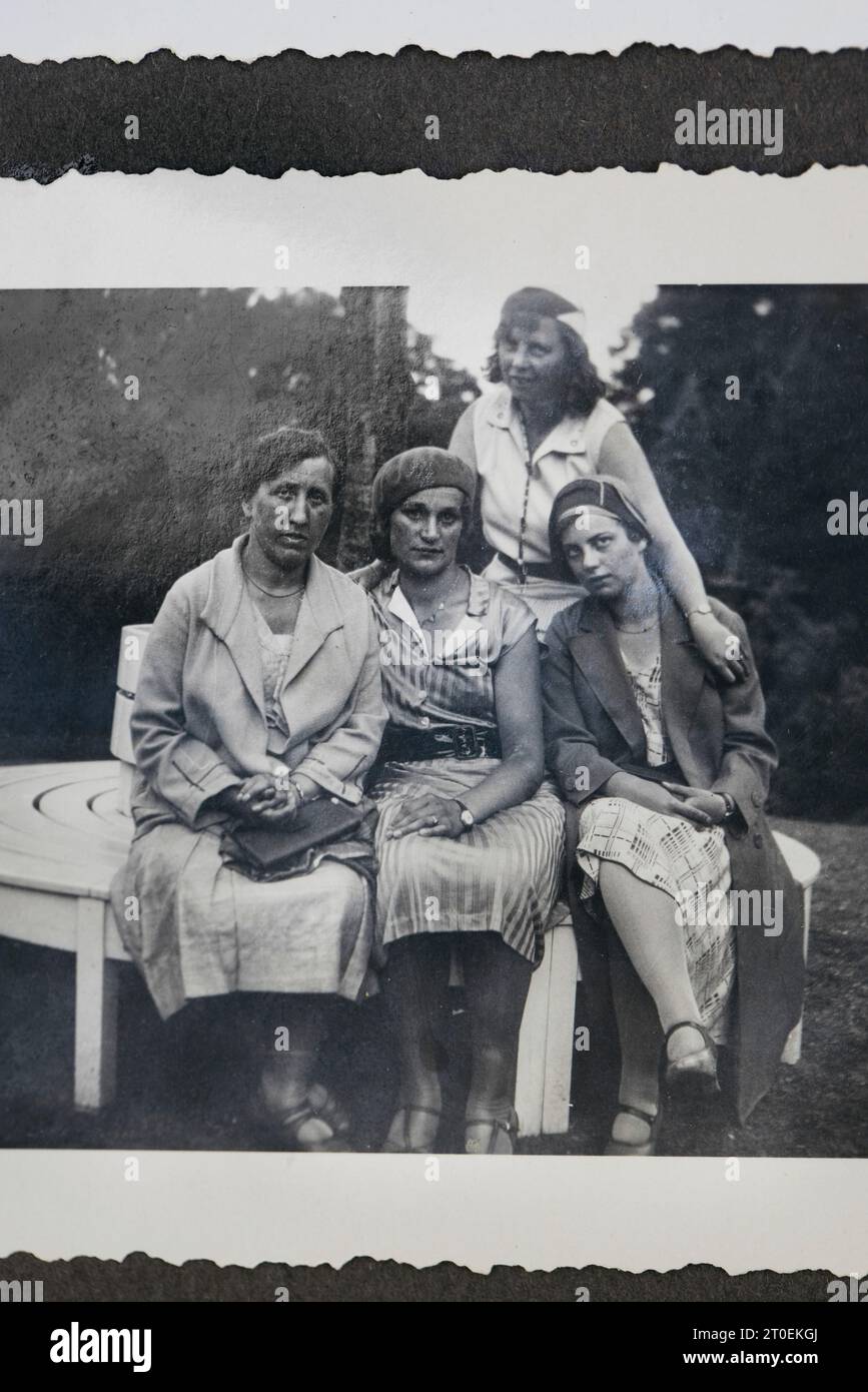 Sehen Sie im Fotoalbum nach dem alten Foto von vier Freundinnen Stockfoto