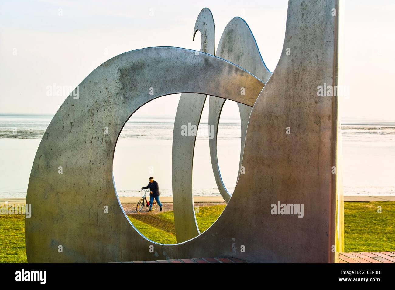 Kunst am Meer, Chrom-Stahl-Seeschlange entführt Radfahrer. Stockfoto