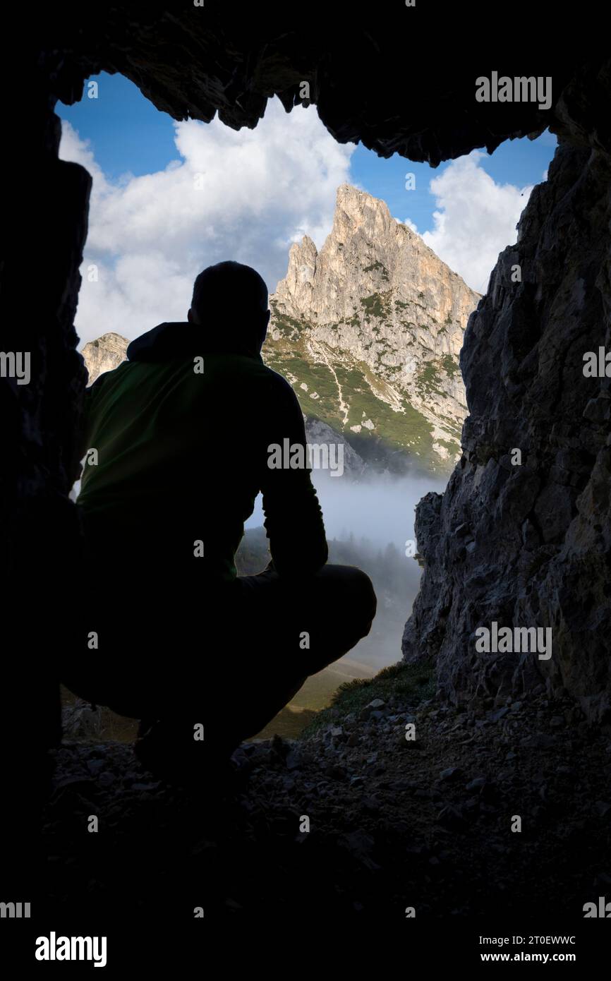 Italien, Veneto, Provinz Belluno, Cortina d'Ampezzo, der Sass de Stria/Hexenstein oder Hexenfels, ein Mann in Silhouette, der von einer Kriegshöhle aus blickt, Dolomiten Stockfoto