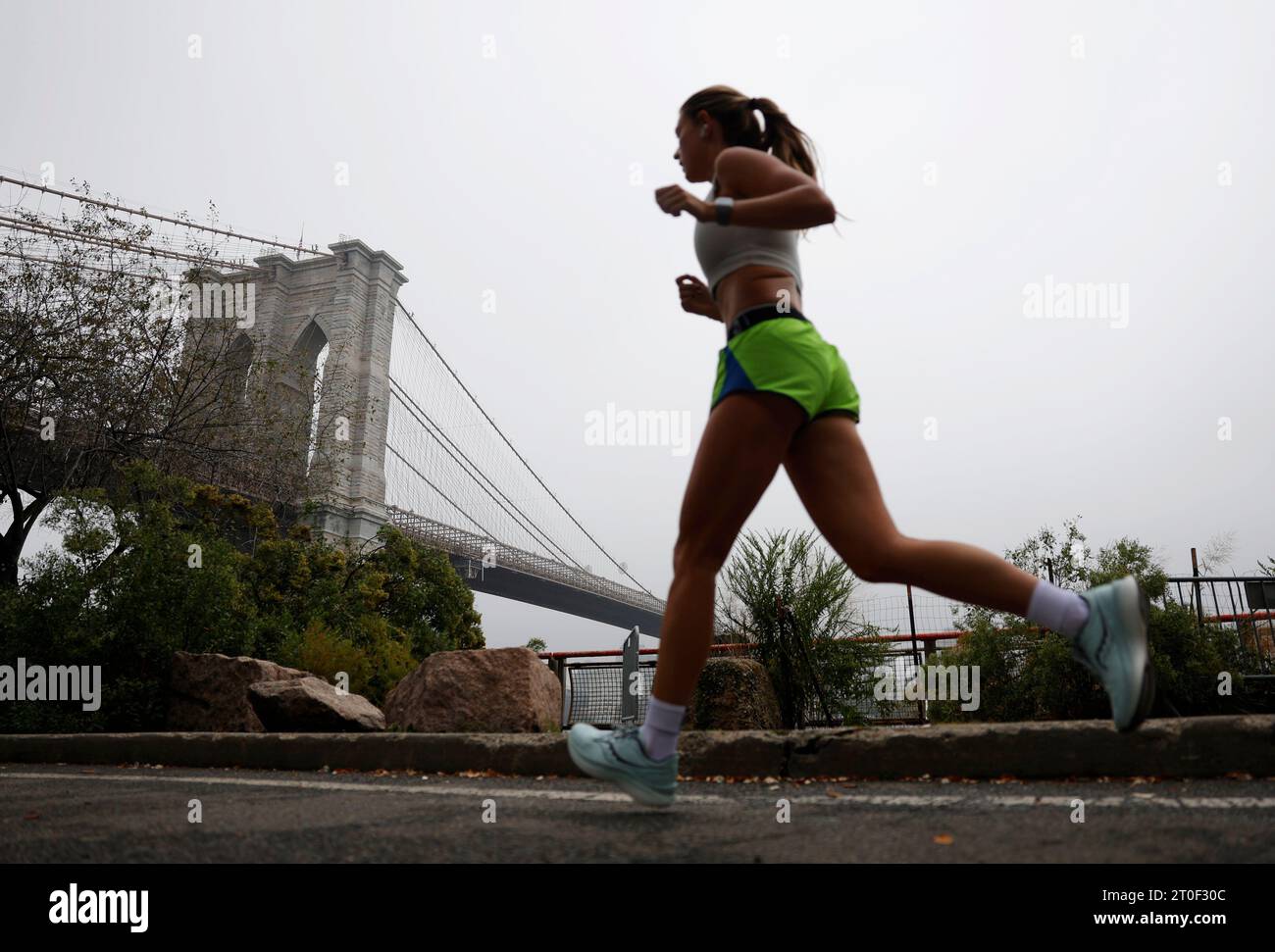 New York, Usa. Oktober 2023. Ein Läufer joggt, wenn leichter Regen in der Nähe der Brooklyn Bridge am Freitag, den 6. Oktober 2023 in New York City durch den Nebel fällt. Foto: John Angelillo/UPI Credit: UPI/Alamy Live News Stockfoto