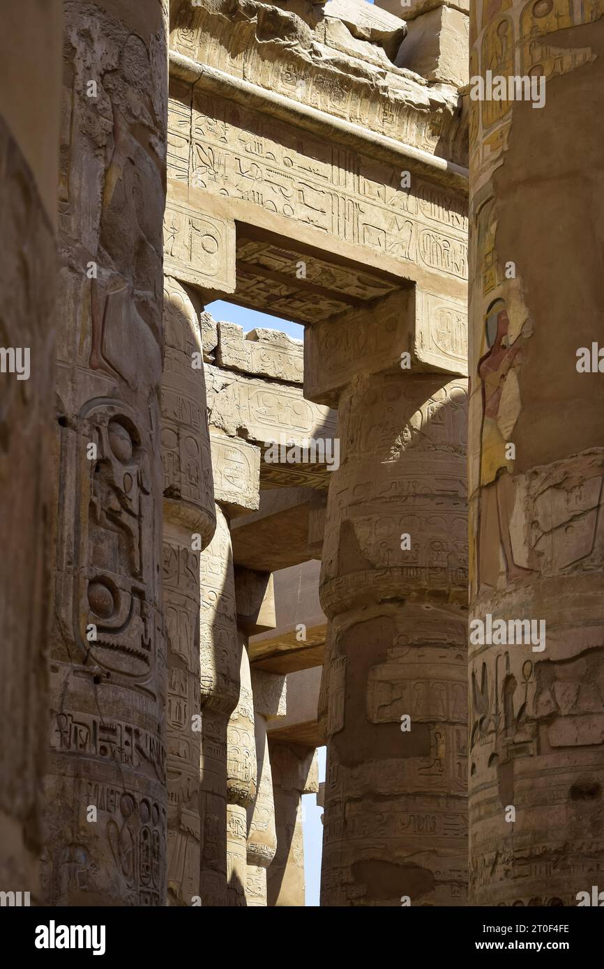 Hohe Säulen des historischen Komplexes des Karnak-Tempels mit geschnitzten alten ägyptischen Hieroglyphen und Symbolen. Große Hypostyle-Halle an den Tempeln von Karnak (A Stockfoto