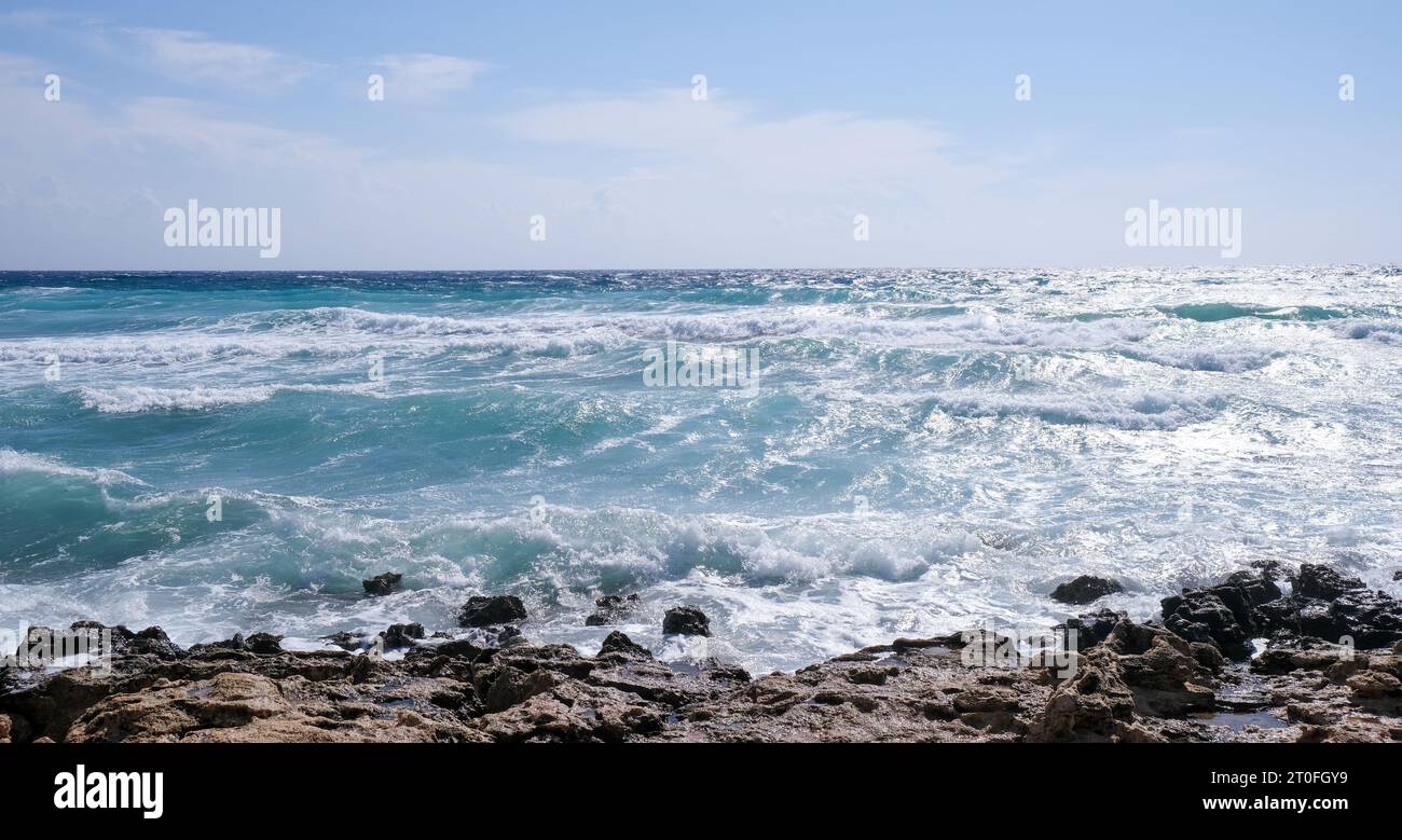 Felsiges Meer mit welligem Ozean und Wellen, die auf den Felsen krachen. Stromiges Wetter Stockfoto