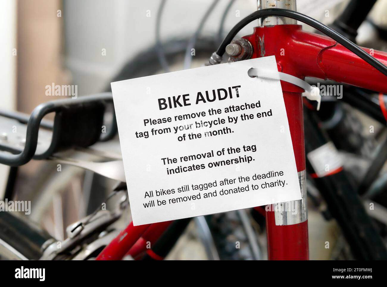 Tag für die Fahrradprüfung an einem Fahrrad mit defokussiertem Fahrradraum des Schichtengebäudes. Prüfmarke für Fahrradausrüstung mit detaillierten Anweisungen. Verwendet, um u zu finden Stockfoto