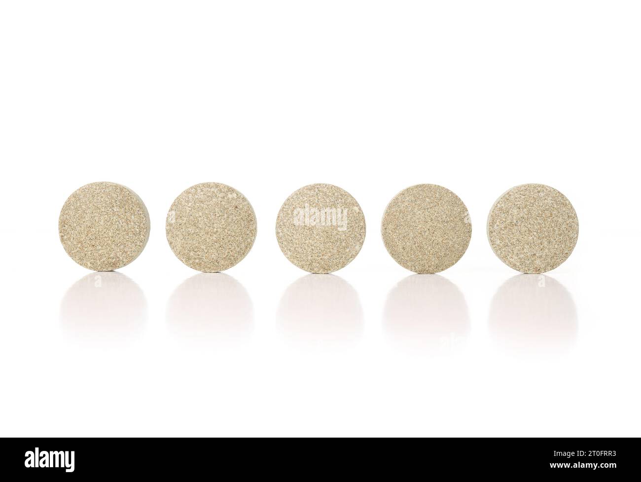 Runde Tabletten in einer Reihe. Mehrere grün strukturierte gepresste Wafer-Tabletten oder -Pillen. Isolierte Multivitamine für Hunde, Nahrungsergänzungsmittel. Selektiver Fokus. Whi Stockfoto