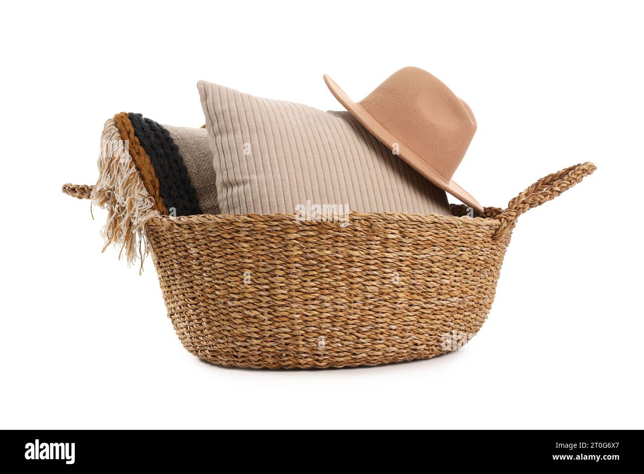 Korb aus Korb mit Kissen und Hut isoliert auf weißem Hintergrund Stockfoto
