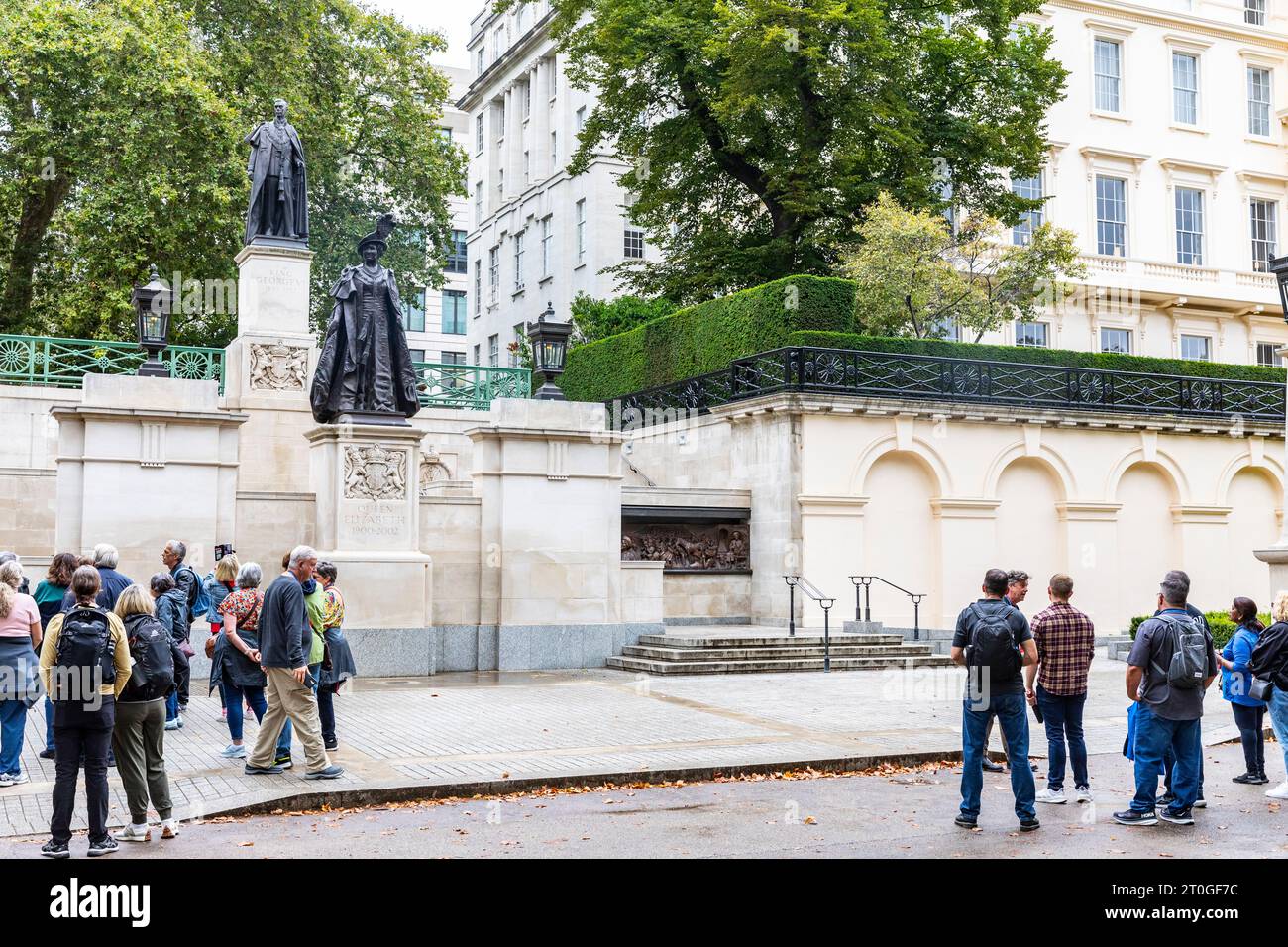 London The Mall, Tour-Gruppen sehen Statuen von Queen Elizabeth der Königin Mutter und König George V1 in der Mall in London, England, Großbritannien Stockfoto