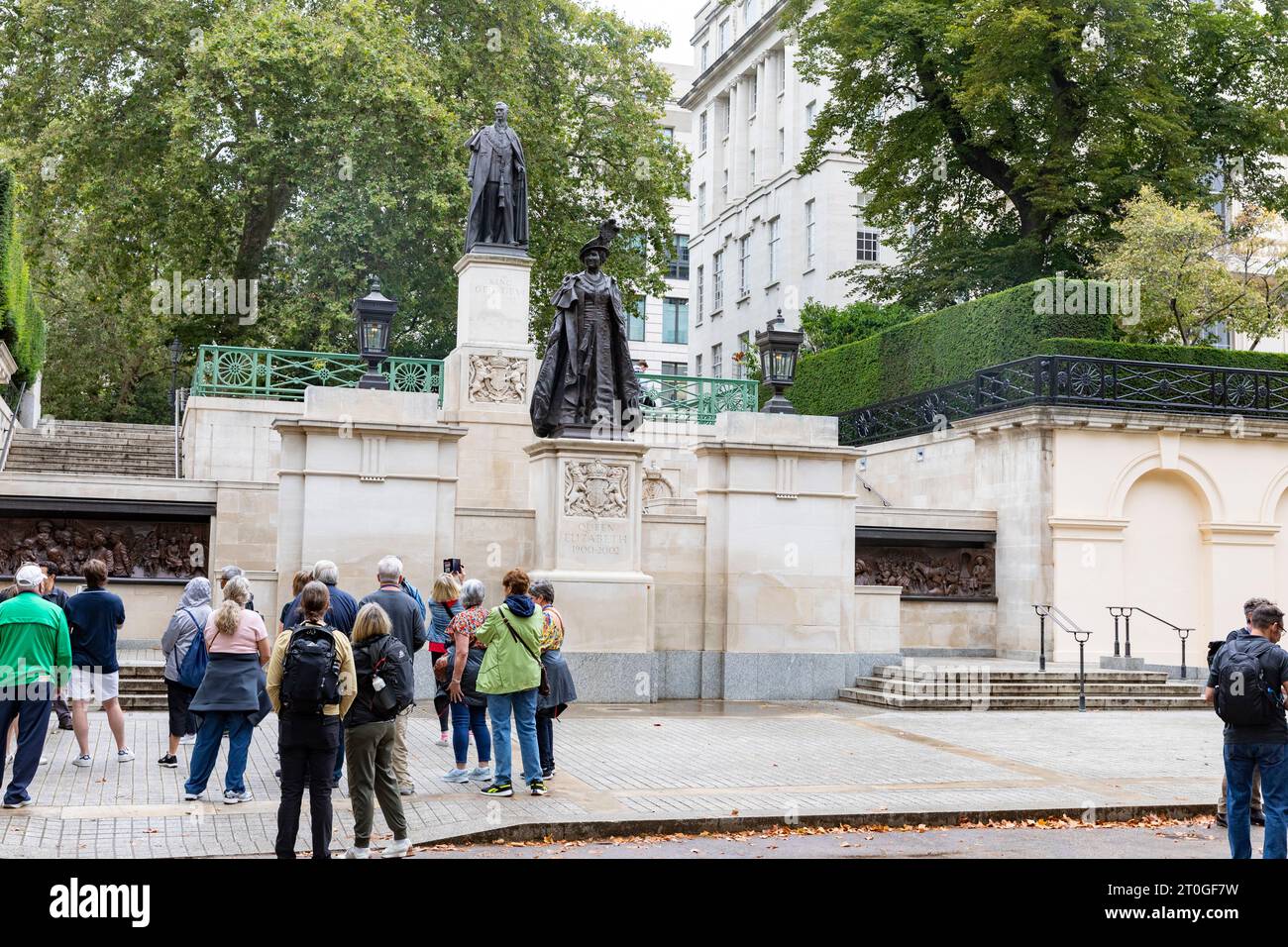 London The Mall, Tour-Gruppen sehen Statuen von Queen Elizabeth der Königin Mutter und König George V1 in der Mall in London, England, Großbritannien Stockfoto