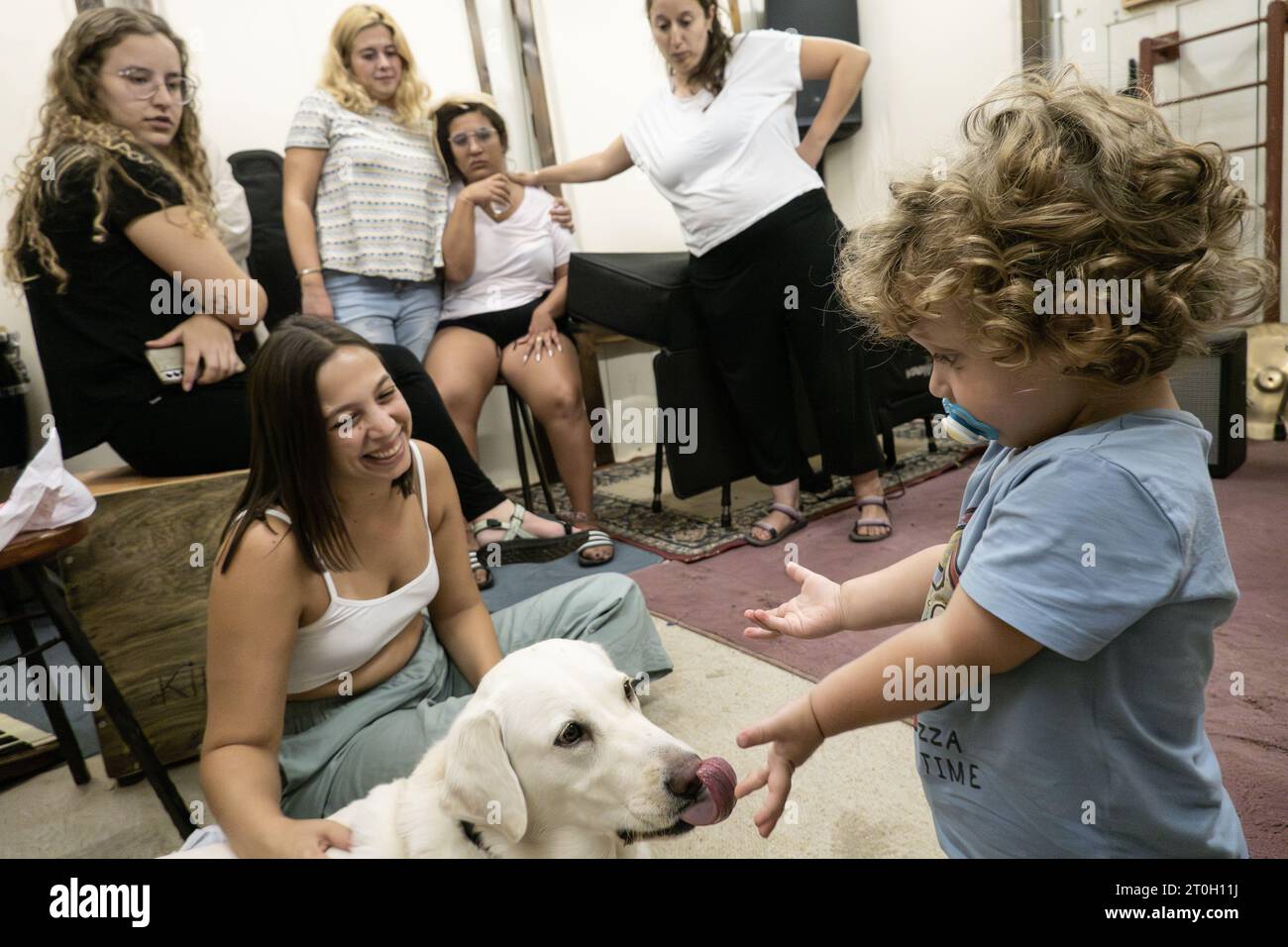 Kibbuz Tzuba, Israel. Oktober 2023. Ein Junge spielt mit seinem Hund in einem Luftschutzbunker, während Zivilisten sich vor dem Geräusch von Luftschutzsirenen flüchten. Das israelische Militär kündigte nach massiven Raketenfeuern aus dem Gazastreifen und der Infiltration von bewaffneten Männern in israelisches Territorium in einer größeren Eskalation des Konflikts einen Kriegsalarm an. Die Hamas hat die Verantwortung übernommen. Quelle: Nir Alon/Alamy Live News Stockfoto